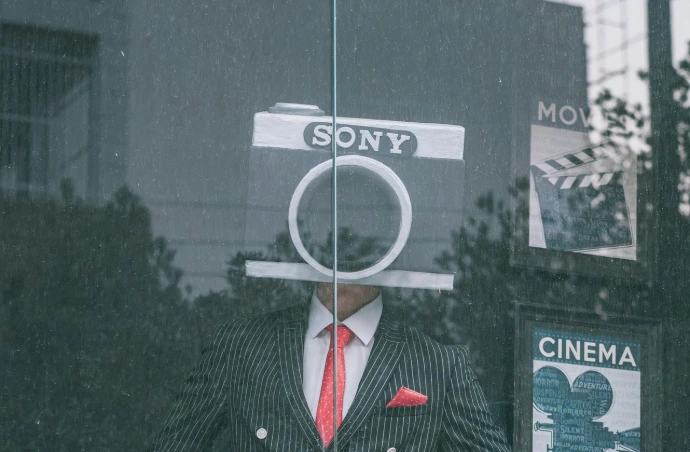 person in black and gray pinstripe suit jacket holding magnifying glass